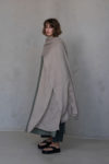 Minimalist natural flax scarf styled as a shawl with a flowing, airy texture.