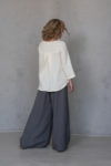 Back view of the Linen Blouse with Back Pleat ROSE, showing the high-low hemline and 3/4 sleeves for a modern silhouette