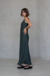 Side view of the Bias-Cut Linen Dress VERED in dark green, showcasing its graceful drape and timeless design.