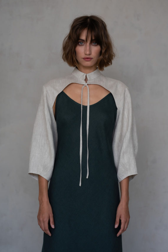 Front view of the reversible linen bolero, featuring a minimalist open-front design with statement puff sleeves