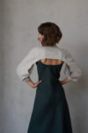 Back view of the reversible linen bolero, showcasing the dramatic puff sleeves and cropped design in natural linen.