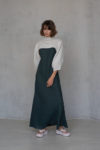 Model wearing the reversible linen bolero with puff sleeves, styled over a dark green dress for a refined look.