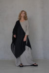 Open-weave linen overlay in black draped over a minimalist dress, creating a sophisticated and timeless silhouette