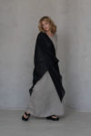 Side view of black linen wrap layered on a beige dress, showing its long slits and elegant flow