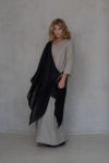 Versatile black linen wrap worn as an overlay, creating a modern layered look on a neutral-toned dress.