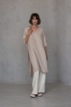 V-neck linen tunic RONA in soft ivory color, showcasing its minimalist design with a high-low hemline, side slits, and tailored 2/3 sleeves in medium-weight linen