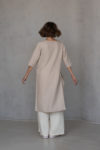 Back view of V-neck linen tunic RONA in elephant bone color, highlighting its flowing high-low hemline and medium-weight linen fabric for a timeless silhouette.