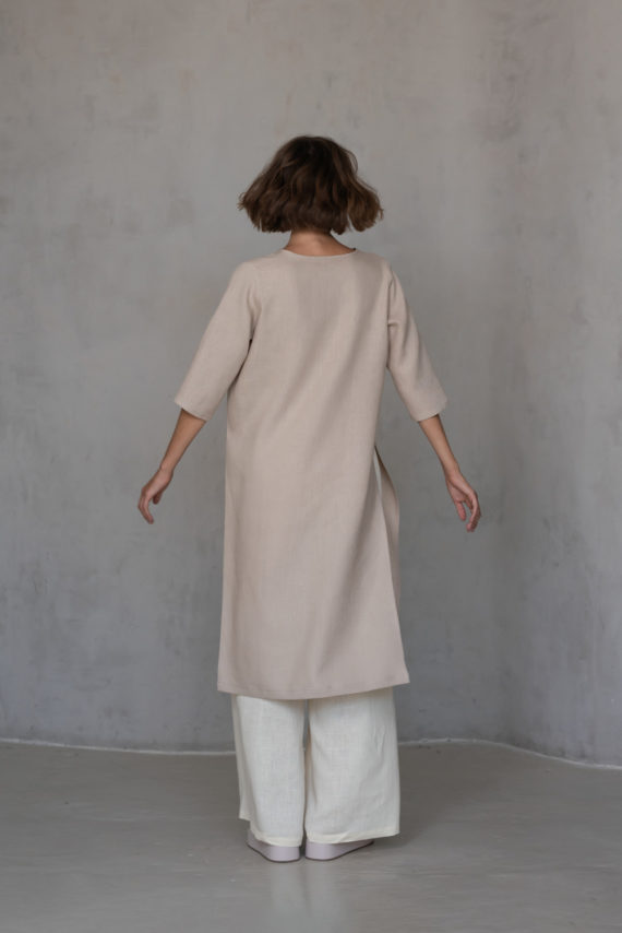 Back view of V-neck linen tunic RONA in elephant bone color, highlighting its flowing high-low hemline and medium-weight linen fabric for a timeless silhouette.