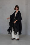 "Natural flax linen cover with a bohemian design, draped elegantly over a white outfit.