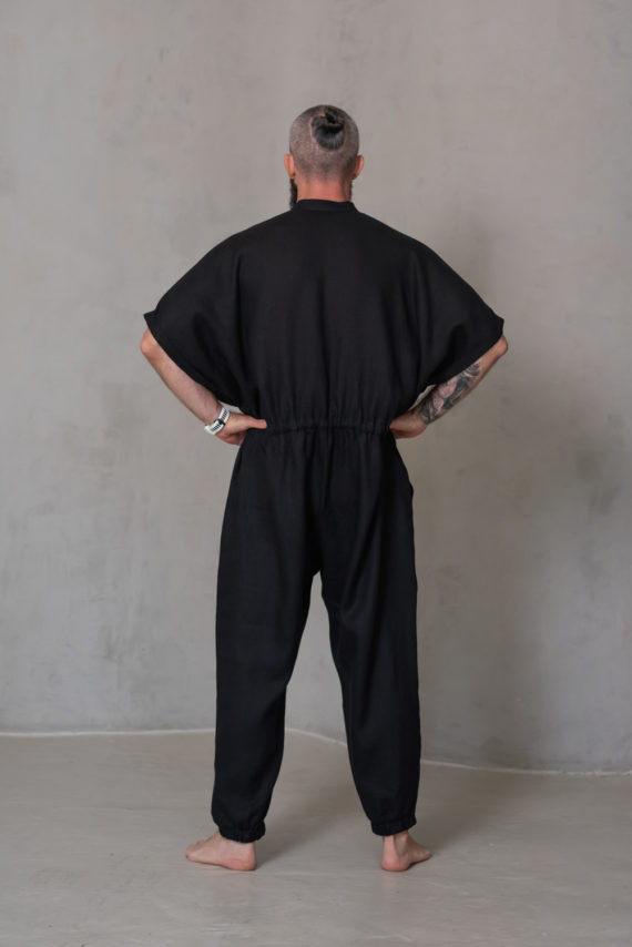 Back view of the men’s linen jumpsuit SIGMA in black, showcasing clean lines, breathable fabric, and elastic cuffs for a functional finish.