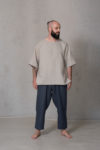 Relaxed linen top with half sleeves in natural flax color, featuring a high-low hem and side slits for effortless style and comfort.