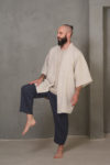 A man modeling the NUEBA linen kimono jacket, highlighting the open-front design and minimalist short sleeves.