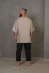 Back view of the relaxed linen top in natural flax color, showing its clean silhouette and smooth linen texture.