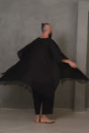 A back view of the DUKAY loose linen jacket in black, showcasing its fringed hem and lightweight design.