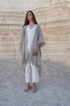 A full-body view of a natural flax Linen Jacket with Fringes, styled effortlessly with white linen pants