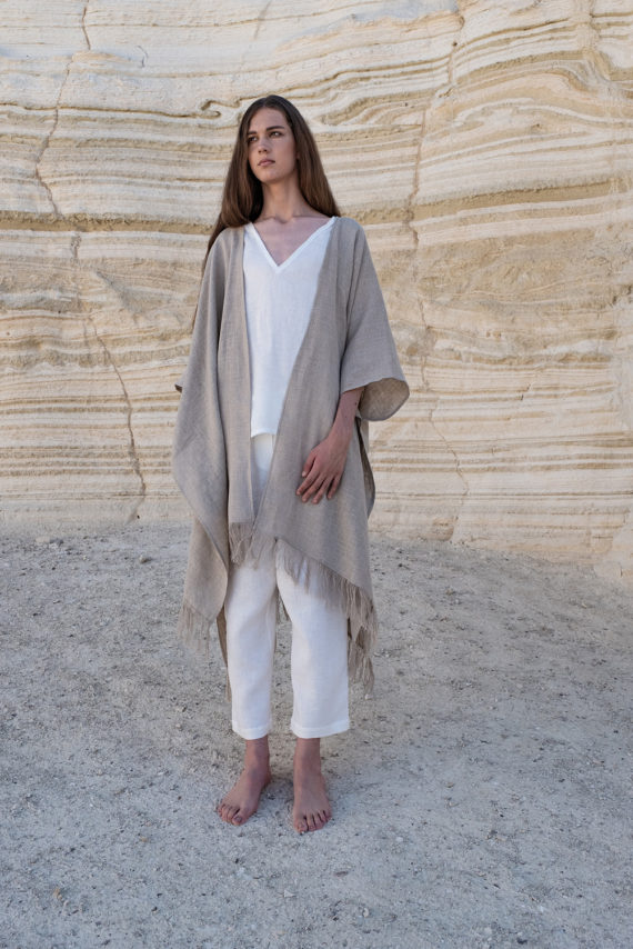 A full-body view of a natural flax Linen Jacket with Fringes, styled effortlessly with white linen pants