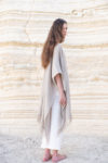 Side profile of a woman in a natural flax Linen Jacket with Fringes, highlighting the breathable open weave linen fabric.