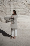 Minimalist natural flax Linen Jacket with Fringes draped over shoulders, showcasing its lightweight and flowy texture.