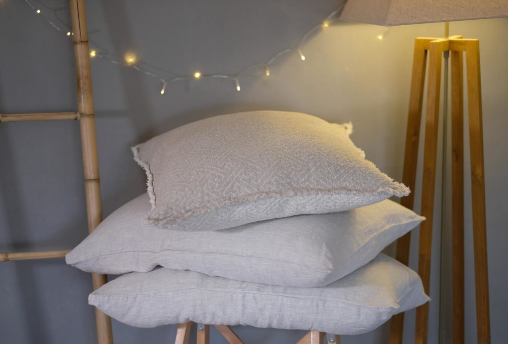 Layered linen pillow covers in neutral tones on a couch